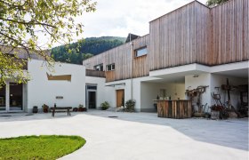 Wolfsbräu - the humpbacked world beer, © Familie Wagner Modern building with wooden cladding and inner courtyard.