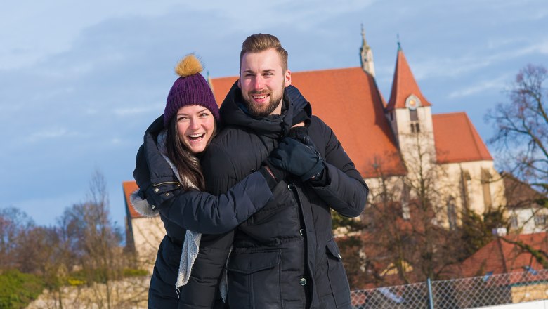 Ice rink in Eggenburg, © Jarmer Margarete A couple on an ice rink, in the background a church with a red roof.