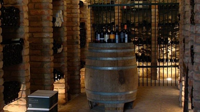 Wine cellar, © Landgasthof Hotel Muhr A wine cellar with brick walls, wine racks and a barrel in the middle.