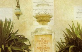 Young blood monument, © Erdäpfelmuseum Prinzendorf Monument with inscription, surrounded by plants and a basket of potatoes and sunflowers.