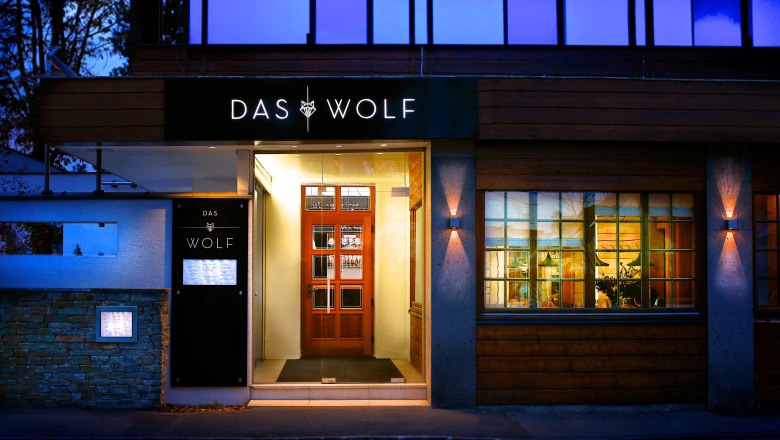 TDR-The Wolf entrance, © Das Wolf Restaurant entrance at dusk with bright light on the door and the Wolf lettering