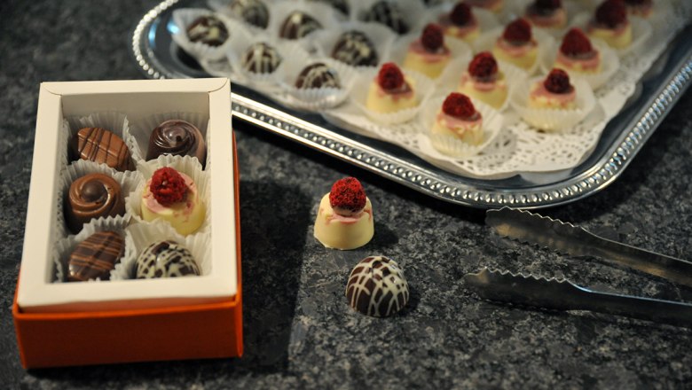 STYX chocolates, © Styx Naturkosmetic GmbH A box of chocolates and a tray of chocolates on a table.