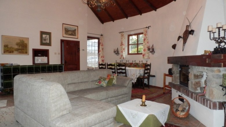 Living room, © Ivan Sigl Cozy living room with grey sofa, fireplace and dining table. Rustic decoration and wooden beamed ceiling.