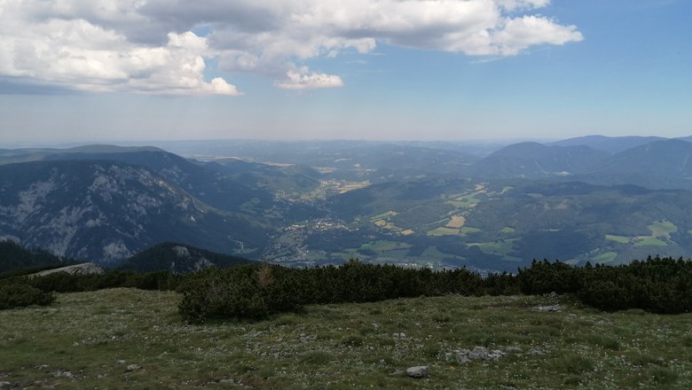 Jakobskogel on the Rax, © Wiener Alpen View from the Jakobskogel on the Rax over a wide mountain landscape with valleys and forests under a cloudy sky.