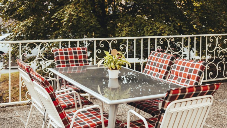 A place in the green is also available, © Niederösterreich Werbung/David Schreiber Garden table with checkered chairs and plant on terrace.