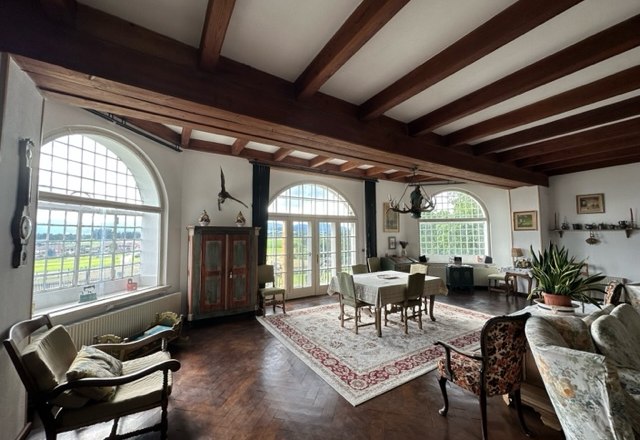 Ziegersberg Manor, © Schloss Gut Ziegersberg An elegant living room with wooden beamed ceiling, large windows, antique furniture and a carpet.