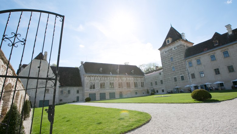 Walpersdorf Castle Entrance, © Schwarz-König.at Entrance to Walpersdorf Castle with open gate, lawn and historic building in the background.