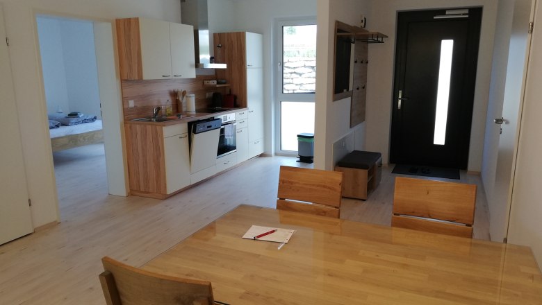 Eat-in kitchen, © Peter Hecht Modern eat-in kitchen with wooden furniture, dining table, kitchenette and entrance door.