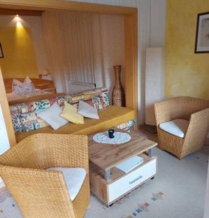 Guest room Weixelbaum, © Familie Weixelbaum Cozy guest room with rattan furniture and colorful sofa.