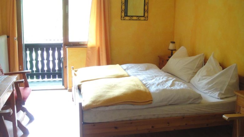 Room Jägerstube, © Familie Kellner Cozy room with wooden furniture, yellow walls and balcony.