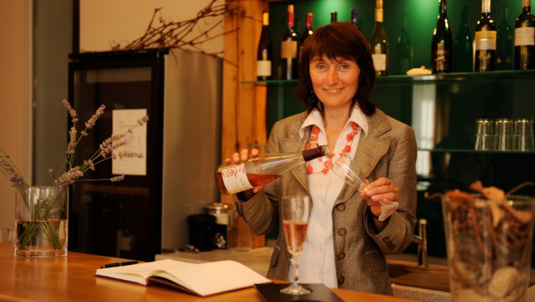 Tasting, © Steve Haider Woman pouring wine into a glass at a bar.
