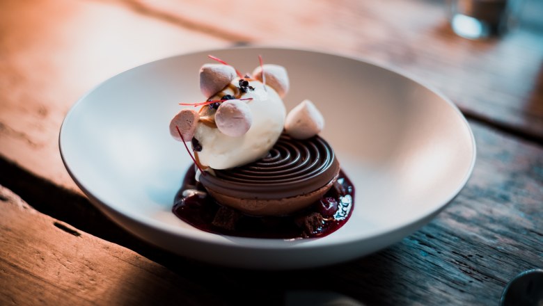 Chocolate dome - mousse / brownie / ice cream / crumble, © Vinzenz Pauli/Philip Hinteregger A dessert with ice cream, mousse and crumble served in a bowl.
