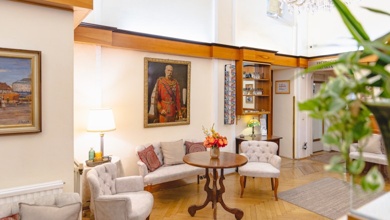 Hotel Central Reception, © busyshutters/ Hotel Zentral Schwartz GmbH Elegant hotel lobby with paintings, seating area and flowers on the table.