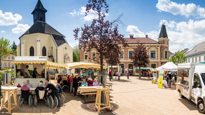 Marketplace Gloggnitz, © Wiener Alpen/Zwickl Market square in Gloggnitz with church, stalls and people.