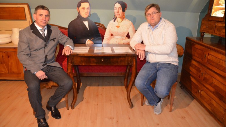 Museum Neupölla, © Gemeinde Neupölla Two men sit at a table with two cardboard figures in a room with antique furniture.