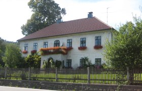 Gsolhof dirndl store, © zVg A two-storey house with red roof tiles and flower boxes on the windows.