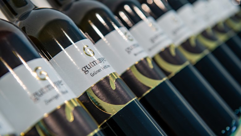 Diverse range of wines, © Martin Lifka Photography Close-up of wine bottles with the label 'Gutmayer Grüne Veltliner'.