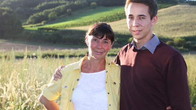 Winery Thüringer, © Weingut Thüringer A woman and a young man stand in a rural landscape and smile at the camera.