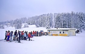 Aichbelberg lifts Karlstift, © Waldviertel Tourismus, Reinhard Mandl Skiers stand in a queue in front of a ski lift in a snowy winter landscape.
