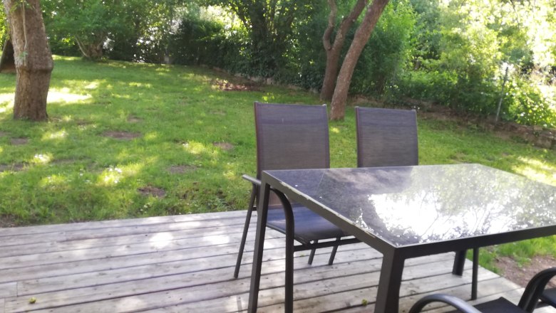 Terrace, © Günter Lammer Terrace with table and chairs, surrounded by green garden.