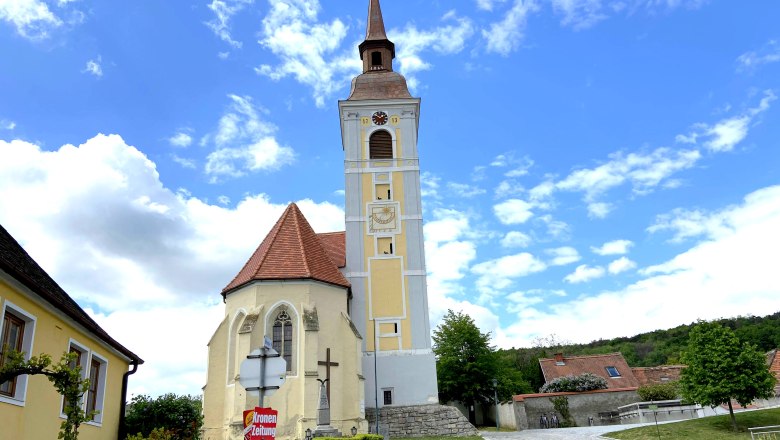 Leaning tower of Waitzendorf, © Weinstraße Weinviertel Church with leaning tower in Waitzendorf, surrounded by blue sky and clouds.