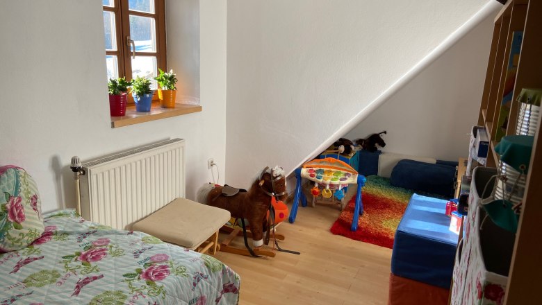 Children's room with play corner, © Wiener Alpen Children's room with bed, toys and colorful carpet.