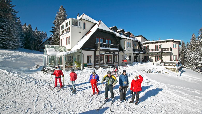 Alpengasthof Enzian in winter, © Alpengasthof Enzian, Foto Franz Zwickl Winter scene with Alpengasthof Enzian and skiers in the snow.
