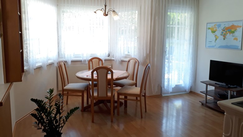 Eat-in kitchen, © Barbara Muck Bright eat-in kitchen with dining table, chairs, TV and world map on the wall.