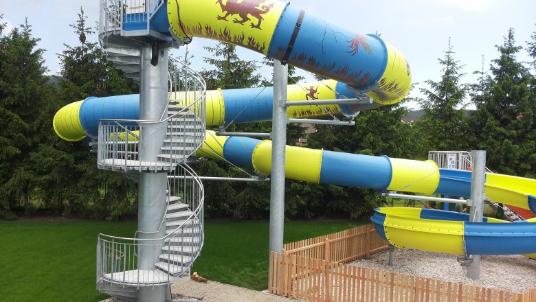 Large water slide, © Dagmar Ackerl Large water slide with blue and yellow tubes and spiral staircase.