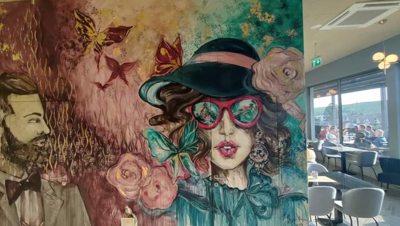 Rooftop entrance area, © Rebecca Freitag Wall painting with stylized portraits of a man and a woman in a café.