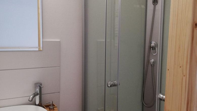 Bathroom double room, © Familie Weibels Small bathroom with shower, washbasin and mirror.