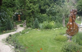 SculptureNature garden, © Harry Raab A green garden with sculptures and a curved gravel path.