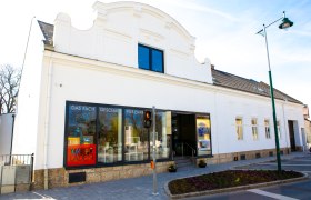 Hacker House, © Harald Wrede A white building with shop windows