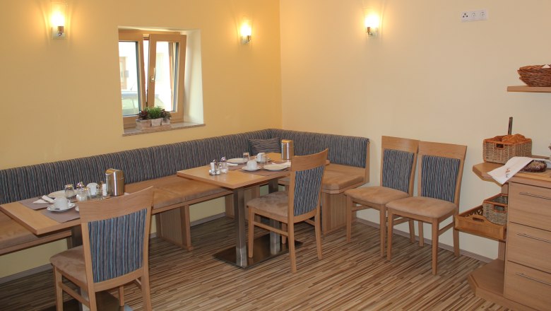 Guesthouse Woditschka, © Fam. Woditschka Cozy breakfast room with wooden furniture and table setting.