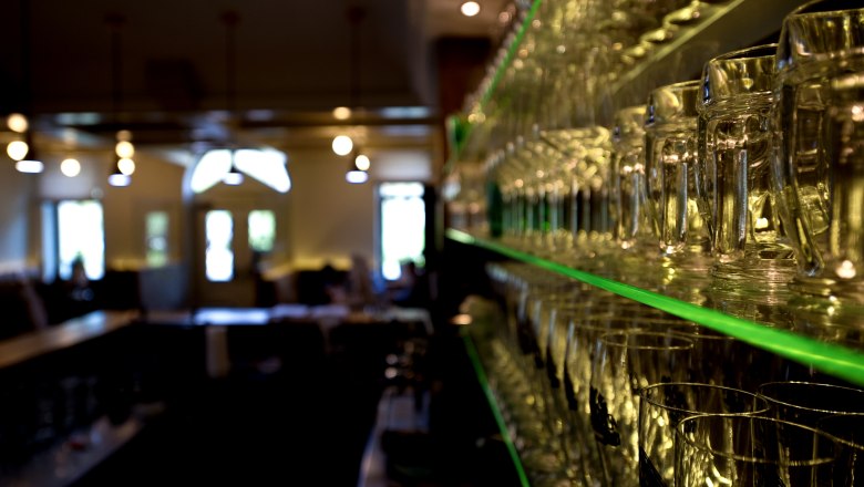 Moravian Embassy, © tonality Shelf with glasses in a restaurant, blurred background.