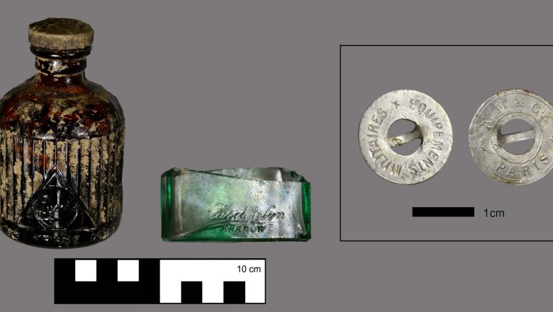 Excavation finds: English & Polish glass bottles, French uniform button, STALAG XVII B, © ASINOE GmbH Excavated finds: glass vial and uniform button.