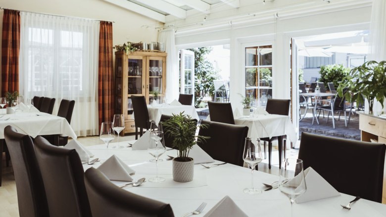 Living wild pub culture, © Niederösterreich Werbung/David Schreiber Elegant restaurant with white tablecloths and glass front facing the terrace.