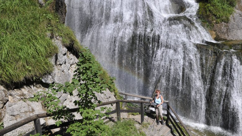 Palfau waterhole gorge, © fotosoos.at A woman stands on a staircase in front of a waterfall in the Palfau waterhole gorge.