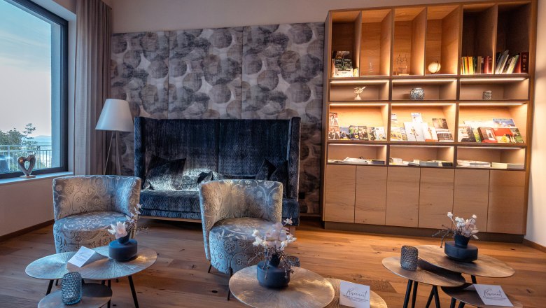 Hotel Schachner, © Niederösterreich Werbung / Maximilian Pawlikowsky Cozy hotel lounge area with armchairs, coffee tables and bookshelf.