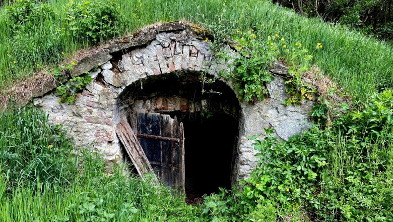 Hannelmühle wine cellar lane, © Weinstraße Weinviertel Entrance to an old wine cellar in a green landscape.