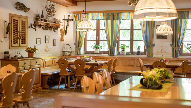 Restaurant, © Familie Langthaler Cozy dining room with wooden furniture, decorative lamps and plants on the tables.
