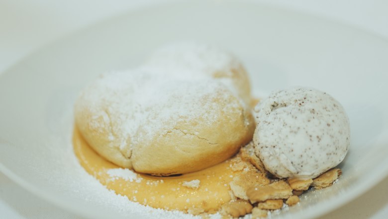 Buchteln with apricot jam and poppy seed ice cream, © Niederösterreich Werbung/David Schreiber Buchteln with powdered sugar, apricot jam and poppy seed ice cream on a plate.