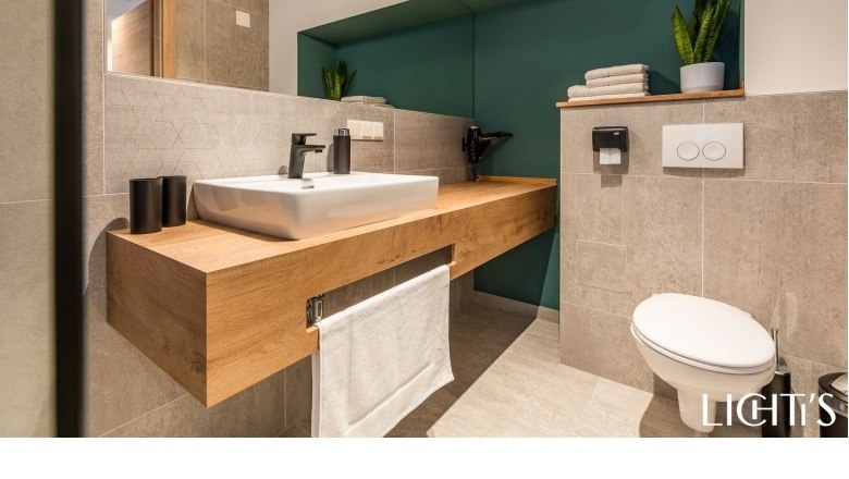 Bathroom, © Lichti´s Appartements-Christian Kremsl Modern bathroom with wooden washbasin, washbasin, towel rail and toilet.