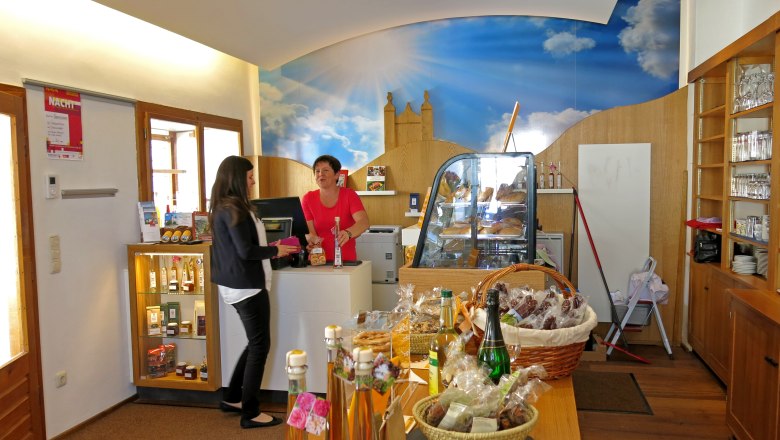 Sonntagberg Visitor Center, © sonntagberg.at Interior view of a visitor center with two women at the counter and various products on a table.