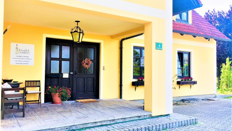 Country house entrance, © Fam. Ritz Entrance to a yellow country house with black door, lantern and floral decoration.