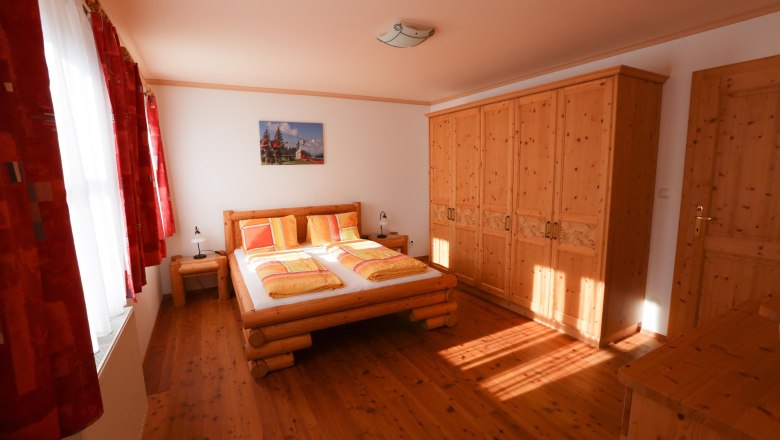 Mountain meadow bedroom, © schwarz-koenig.at Bedroom with wooden furniture, double bed and closet.