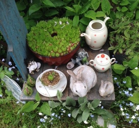 Nostalgic eye-catchers, © Erika Pascher Garden arrangement with teapot, cup, rabbit figurines and succulents.