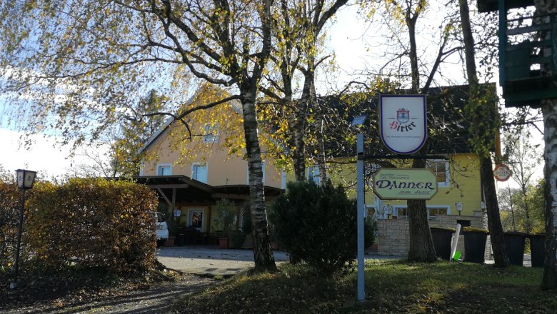 Danner Inn, © Roman Zöchlinger Gasthaus Danner with trees in the foreground and a sign.