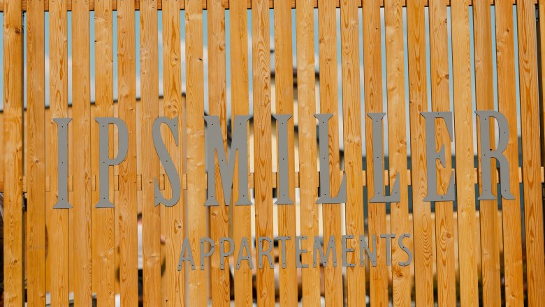 Ipsmiller Apartments, © Michael Reidinger Wooden fence with lettering 'Ipsmiller Appartements'.