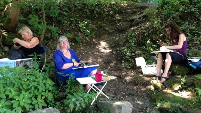 Vernissage Kultur Punkt Hardegg, © Rosi Grieder Three women sit outside and draw in a wooded area.